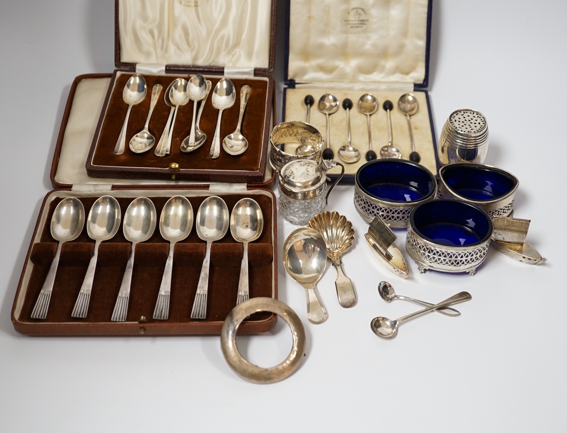 A white metal pepperette modelled as barrel and other silver and plated items including a Georgian caddy spoon, condiments, three cased sets of silver spoons, etc.